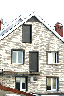 Камень Белый на стене дома фото